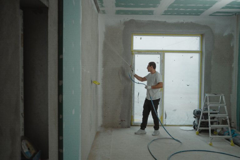 Construction worker applying drywall in newly renovated space, post-construction cleaning services in Smithtown, NY.